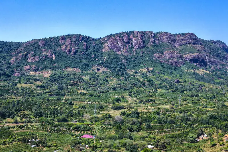 Rocky hills above green farms and homes in Makueni County.